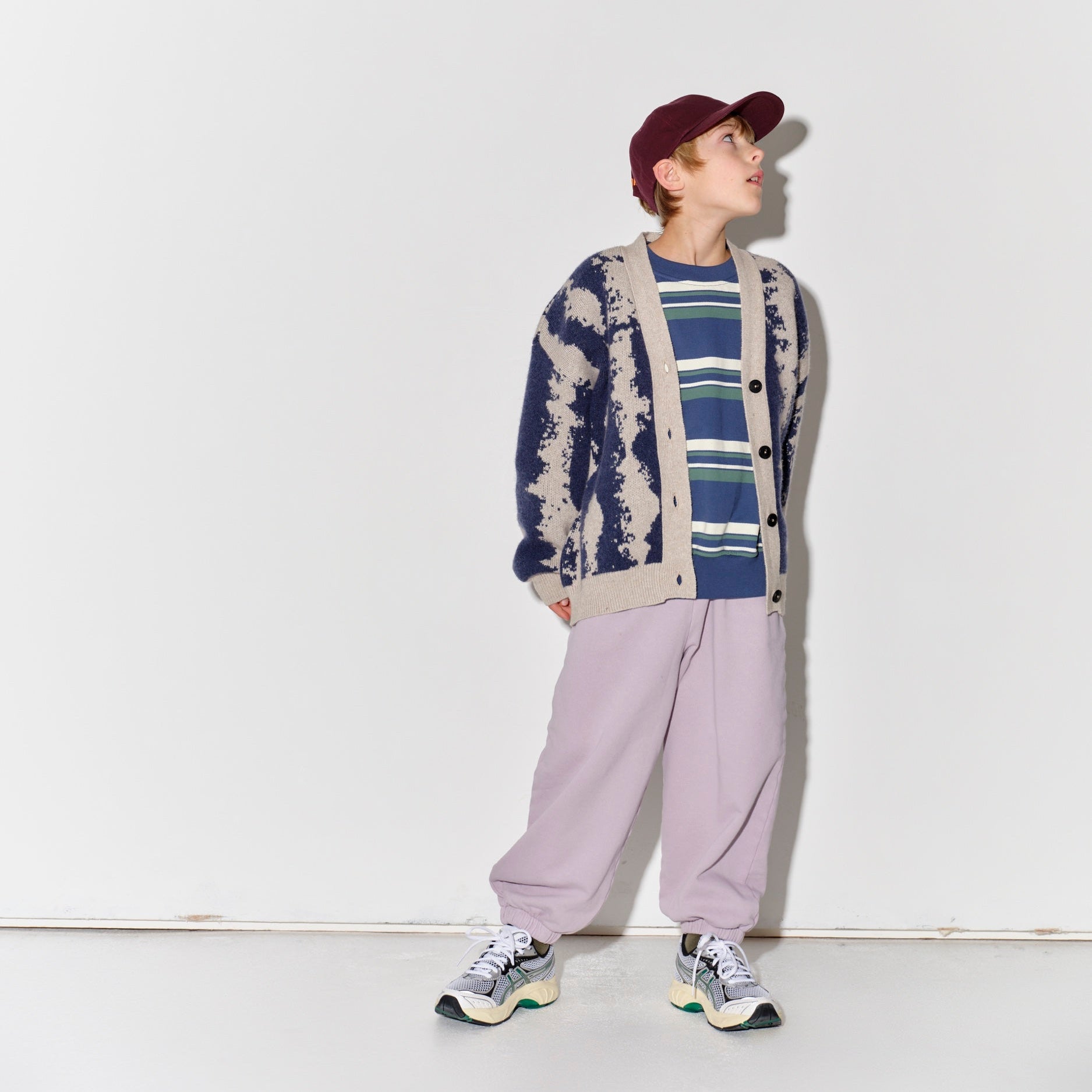 Child wearing a Main Story knit cardigan, striped shirt, and light purple pants