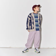 Child wearing a Main Story knit cardigan, striped shirt, and light purple pants