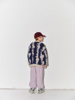 Child wearing a Main Story knit cardigan, striped shirt, and light purple pants