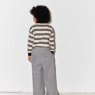 Kid wearing a Main Story long sleeve band tee with ivory and black stripes and gray  sweatpants