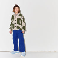 Kid wearing a Main Story patterned sweater and blue painter cargo pants with dark brown knit beanie