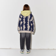 Child wearing Main Story knit cardigan in oat/navy with faded baggy black jeans
